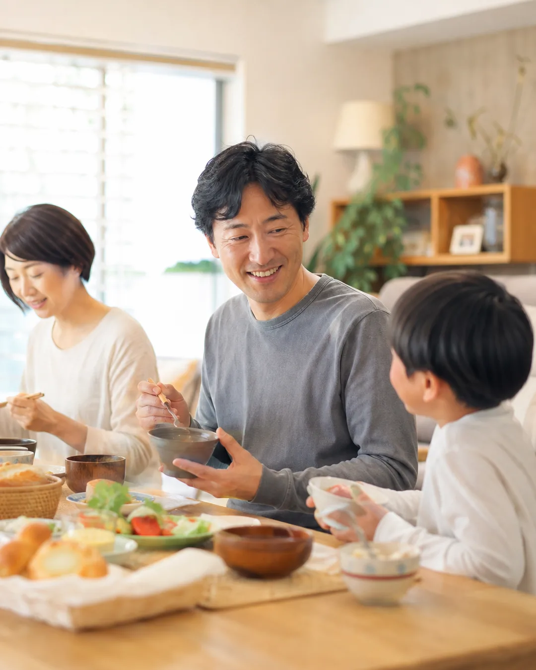 日曜の朝、家族と朝食をとる40代男性